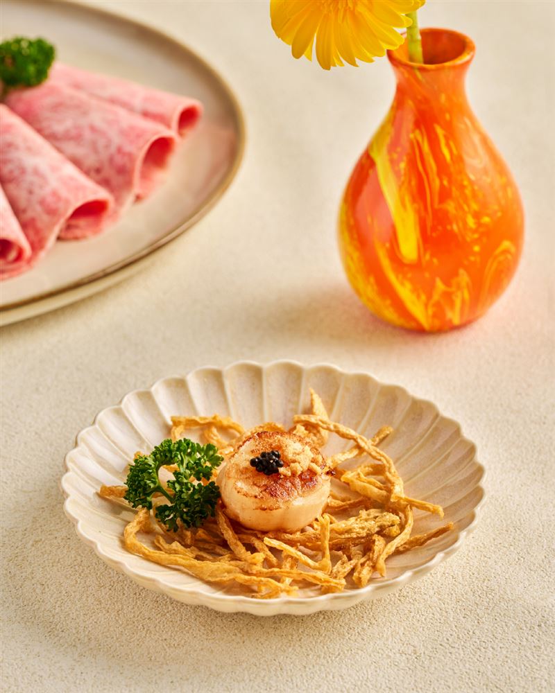 「好事發生・壽喜燒限定套餐」中包涵創意海味「蒜香干貝煎」,以魚子醬作點綴,品嚐得到干貝的甜、魚子醬的鮮,更加入炸鱈魚絲以及可樂果,增加獨特風味與口感層次。(圖/品牌業者提供)