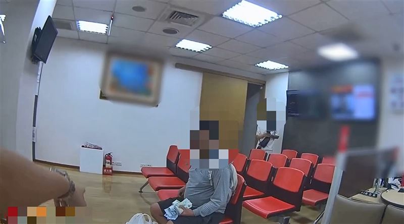 警方到場時王男還在數鈔。(圖/翻攝畫面)