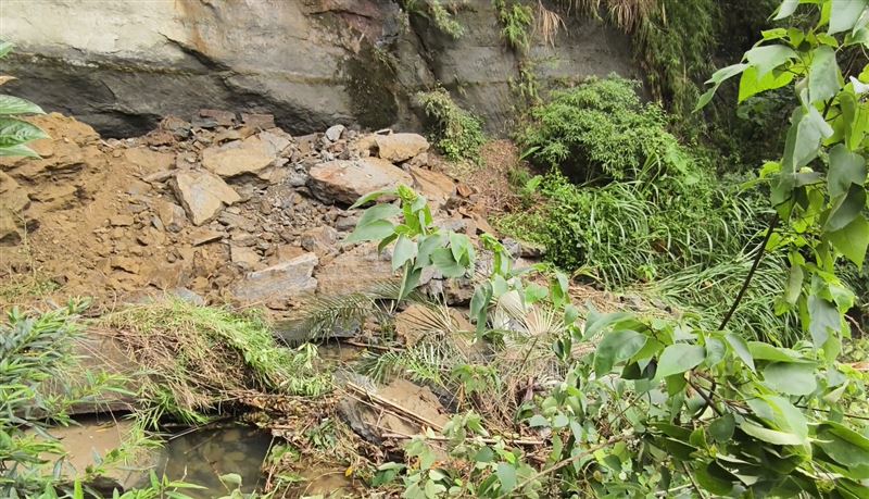 岩層大塊碎石掉落溪中,阻礙水行方向,草莓園園主憂心恐釀災。(圖/翻攝畫面)