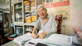 四肢不全的劉天富，僅有2隻手指可以拿筆寫字，他很會寫企劃案、爭取政府補助。（圖／鏡週刊）