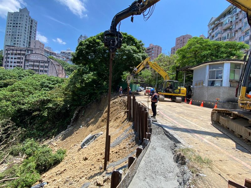 新北市日前午後強降雨造成新店區新坡一街涵煙翠社區前邊坡土石崩落，20日仍持續搶修中。根據監控儀器連續2天數據回報，社區建物狀況穩定，無異常變化。（新北市消防局提供）