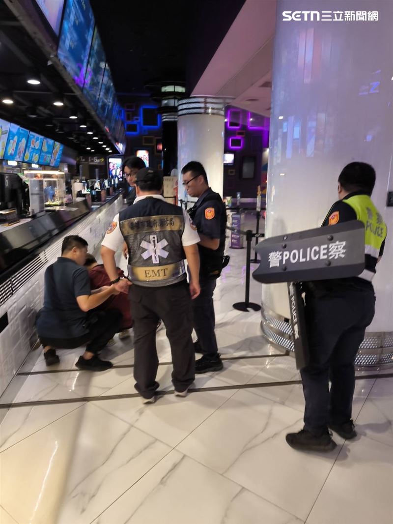 警方獲報後迅速出動盾牌包圍，經過長達一小時的對峙與安撫，影城最終決定交出海報，才成功讓張男棄械並由救護車強制送醫。（圖／翻攝畫面）