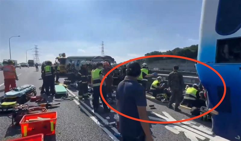 事故現場，整排阿兵哥坐在車道邊傷檢。（圖／翻攝畫面）