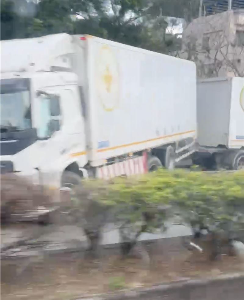 大貨車自撞中央分隔島,導致車身打橫卡在車道上。(圖/翻攝畫面)