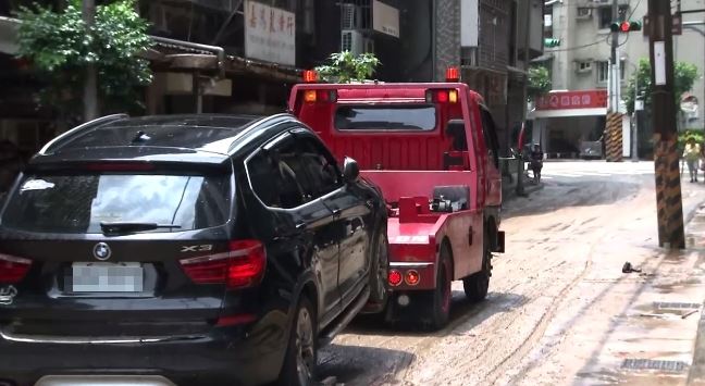 6/25內湖暴雨後街道泥濘，受困車輛被拖走，官方示警傍晚還有一波大雨。（圖／翻攝畫面）
