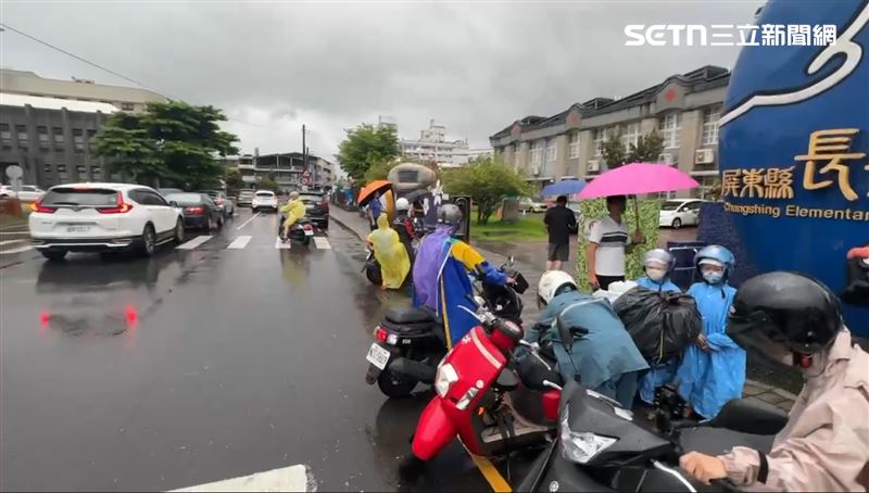 家長冒雨到校門口等著接孩子，批評縣府反應慢半拍。（圖／記者朱俊傑攝影）