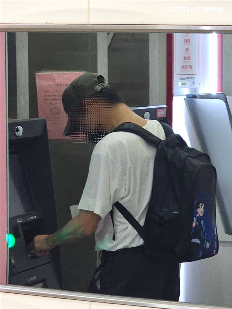 周男揹著卡通背包在提款機附近徘徊，並多次確認手機訊息，詭異舉動引起警方注意。（圖／翻攝畫面）