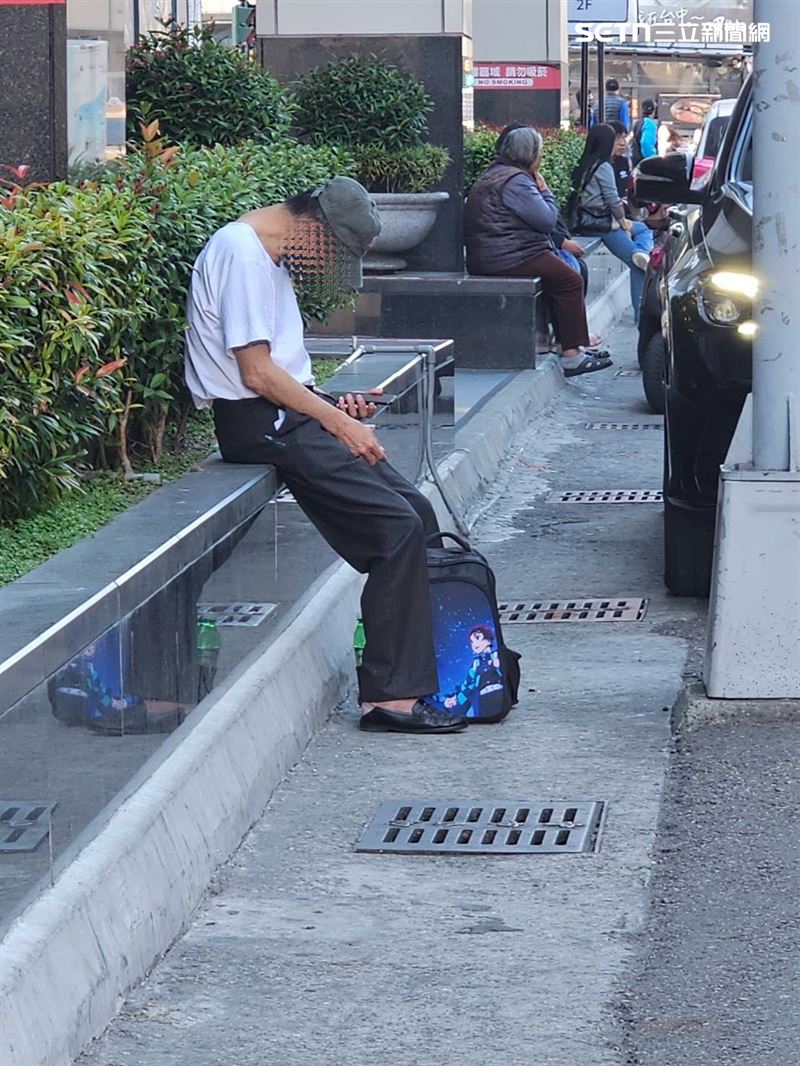 周男揹著卡通背包在提款機附近徘徊，並多次確認手機訊息，詭異舉動引起警方注意。（圖／翻攝畫面）