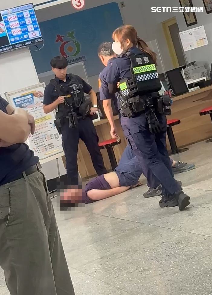 男員工大鬧稅務局後,一度躺在地板上,拒絕配合警方,並要求驗傷。(圖/翻攝畫面)