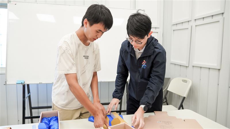 青年局長林楷軒（右）與正修科技大學劉青叡（左）交流產品包裝流程，並關心其工作適應情形及未來規劃。（圖／高雄市青年局提供）