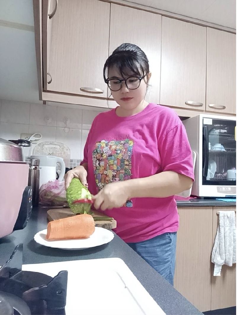 印尼移工阿雅來台從事看護工作，希望未來能申請永居台灣，圖為她為被照護者準備餐點。（阿雅提供）