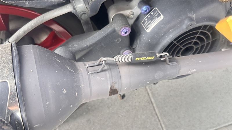 被砸中的機車排氣管。(圖/翻攝畫面)