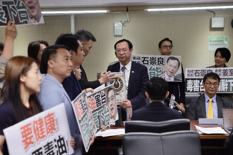 聯油品致癌物苯駢芘超標案滾雪球,立法院社福及衛環委員會8日邀衛福部長石崇良等專題報告「食安問題爆不停,如何構建使國人安心生活、就學與食品廠安全管理精進作為」並備質詢,在野黨立委群起要求官員下台負責,並將象徵毒油的沙拉油桶交給衛福部長石崇良(中右)。(圖/中央社)