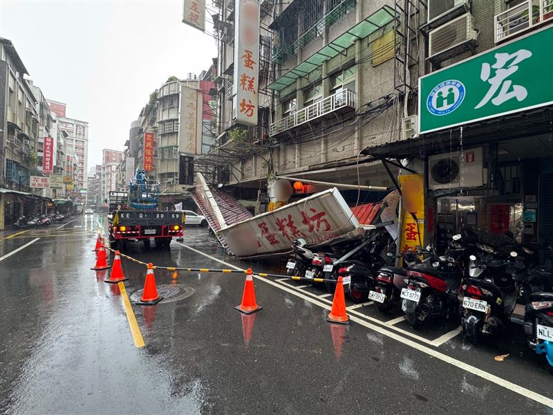 新北市蘆洲區一家老字號蛋糕店及相鄰的五穀雜糧店家招牌斷裂,路邊停放的4輛機車遭波及毀損。(圖/翻攝畫面)