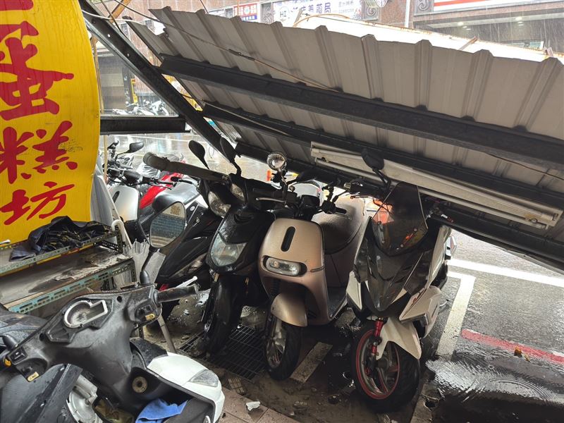 新北市蘆洲區一家老字號蛋糕店及相鄰的五穀雜糧店家招牌斷裂,路邊停放的4輛機車遭波及毀損。(圖/翻攝畫面)