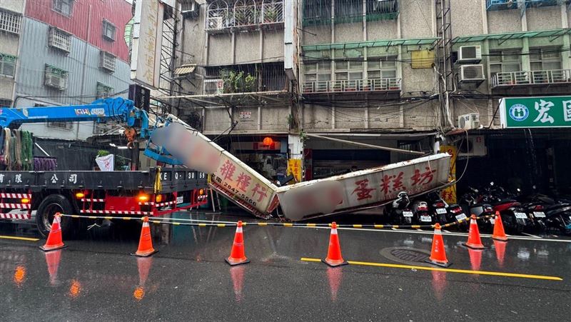 新北市蘆洲區一家老字號蛋糕店及相鄰的五穀雜糧店家招牌斷裂,路邊停放的4輛機車遭波及毀損。(圖/翻攝畫面)