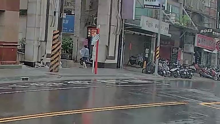 強風吹襲雨傘開花人往後退。(圖/翻攝畫面)