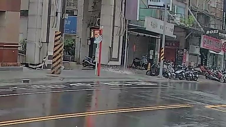 大樓壁磚掉落砸在婦人原本站的位置上。(圖/翻攝畫面)