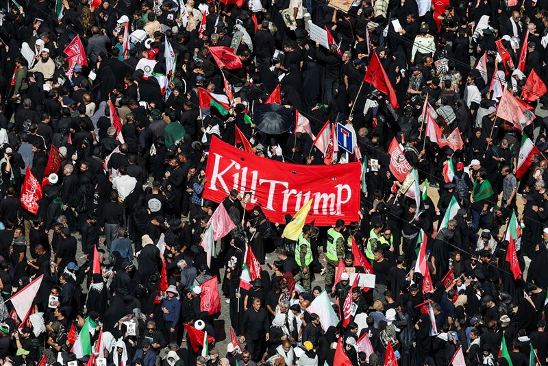 葬禮現場有部分弔唁民眾高舉「We Will Kill Trump（我們將殺死川普）」等標語。（圖／路透社／達志影像）