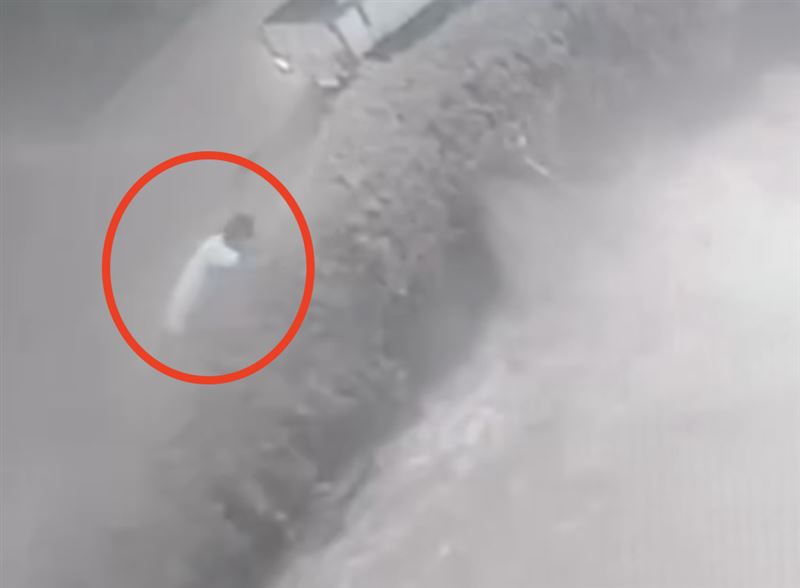 吳姓駕駛想把摩托車抬起,但水流實在太強勁,根本拉不起摩托車。(圖/翻攝畫面)
