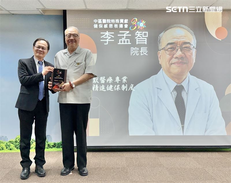 健保署中區業務組組長丁增輝(左),今天下午頒發「特殊貢獻獎」給擔任健保審查委員超過30年、見證台灣健保發展史的衛生福利部臺中醫院院李孟智顧問(右)。(圖/台中醫院提供)