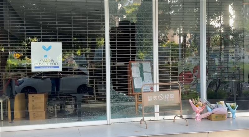 音樂教室鐵門拉下,外頭有民眾哀悼的花束。(圖/翻攝畫面)