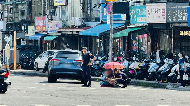 老翁遭撞慘倒滾燙路面　女警借傘遮陽遞水