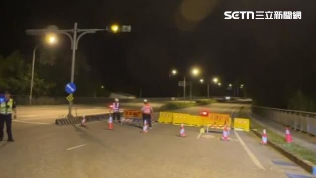 工作人員將萬里溪橋封鎖線拉起實施預警封橋