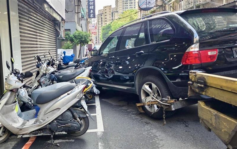 吊掛在後方的報廢車掃倒路邊的13輛機車。(圖/翻攝畫面)