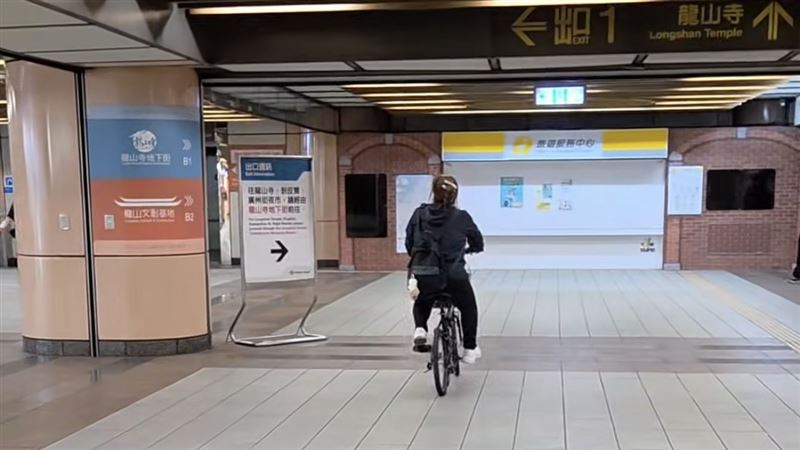 北捷龍山寺站一名黑衣女子在站內騎腳踏車,畫面被一旁民眾拍下PO文。(圖/翻攝自threads@tanoshi9999)