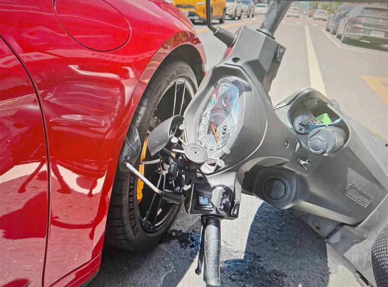 保時捷敞篷跑車被刮出一道長痕跡,外送員的摩托車倒在一旁。(圖/翻攝畫面)