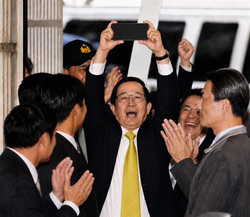 陳水扁將過去自己被上銬時高舉雙手的照片,改為從兒子陳致中手中拿回手機高舉手機的畫面。(圖/陳水扁Threads)