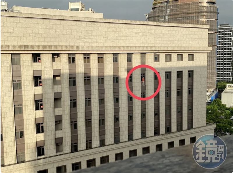 書記官站上桃園地院八樓窗外,虛驚一場。(讀者提供)