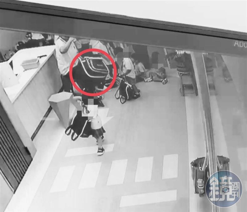 幼童因沒把餐袋放進書包裡,林師便一手抓起書包(紅圈),將書包拋丟到遠處,十分羞辱。(讀者提供)