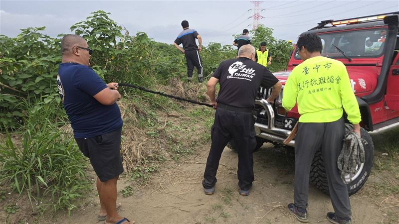 搜救人員利用車子絞盤將老翁遺體拉上岸。(圖/翻攝畫面)