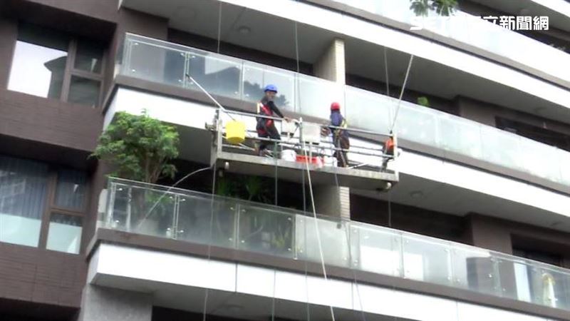 清潔人員吊掛在外牆進行高空清洗作業