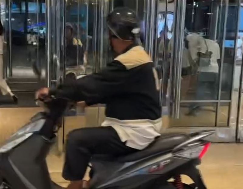 一名頭戴安全帽、身穿夾克與拖鞋的阿北,突然騎乘摩托車,直接闖進新光三越台中中港店1樓大廳。(圖/翻攝Threads@kinmenholly)