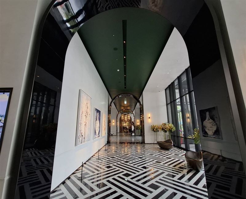 一踏進台北板橋馥華艾美酒店,大廳便以挑高空間搭配黑白幾何紋理地坪、拱形長廊迎接旅客。(圖/記者周佩怡攝影)