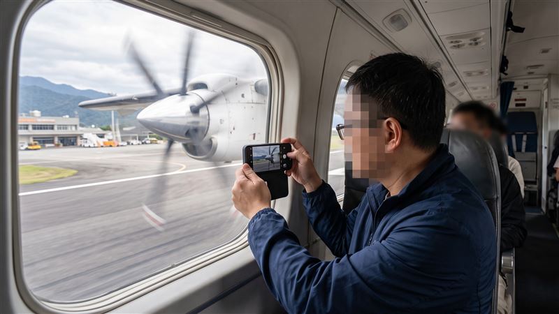 乘客搭機在飛機降落滑行、艙門尚未開啟時,拿手機拍飛機螺旋槳,遭鄰座乘客檢舉,此舉觸犯非法使用干擾飛航、通訊器材罪遭法辦。(示意圖/AI生成)
