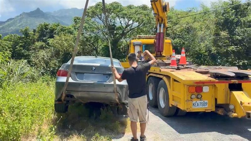 宋男的BMW轎車險墜谷,被拖吊車從邊坡吊回路面。(圖/翻攝畫面)
