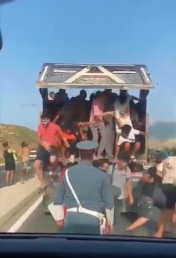 貨車上擠滿非法移民,見到警察攔檢,車廂裡難民紛紛跳車逃竄。(圖/翻攝自X平台 @juanBravoBaena)