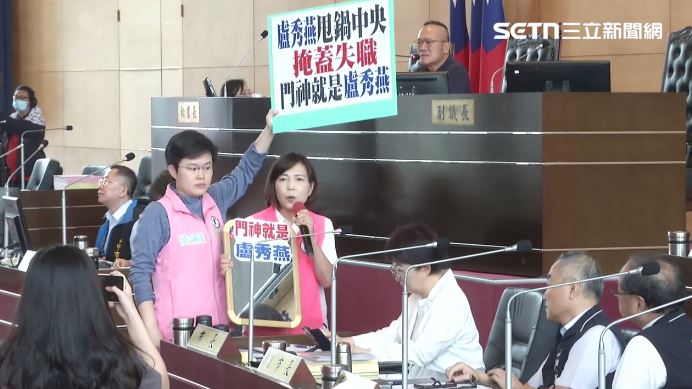 民進黨議員高舉手板表達訴求,盧秀燕僅低頭使用手機,未正面回應。(圖/翻攝畫面)