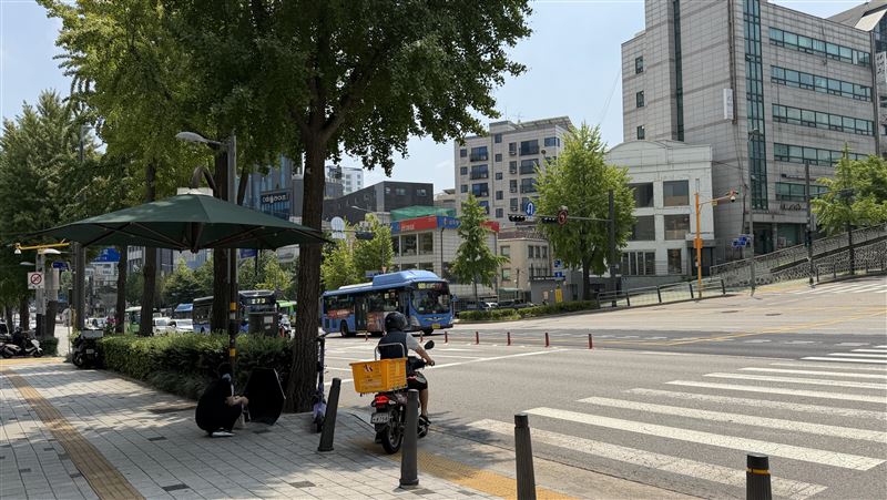 韓國面臨酷暑，韓國內政部稱今夏已16人因高溫喪命。圖為首爾一處斑馬線旁的遮陽傘。(圖／中央社）