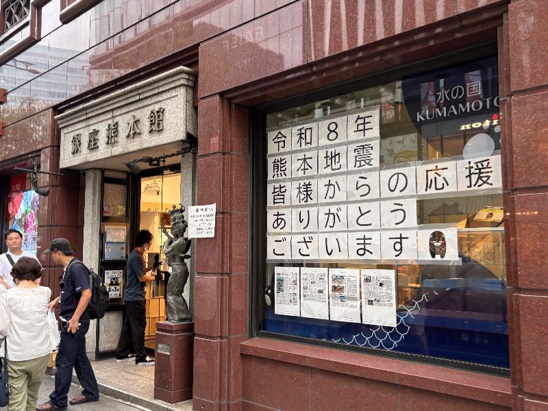 「銀座熊本館」店面朝向大馬路的櫥窗上貼著「令和8年熊本地震,感謝大家的支持」的文字。(圖/中央社)