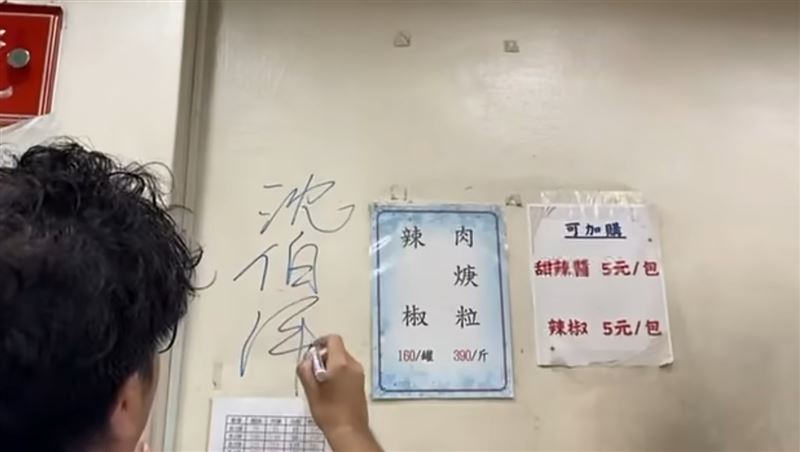 沈伯洋一行人到饒河夜市名店東發號麵線拜票,老闆娘邀請沈伯洋在店內牆上簽名。(圖/翻攝自周軒臉書)
