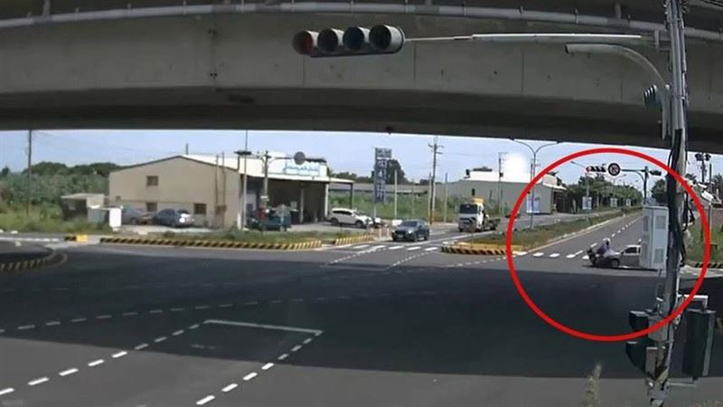 機車遭追撞後卡進車底,騎士被拋飛後重摔落地。(圖/翻攝畫面)