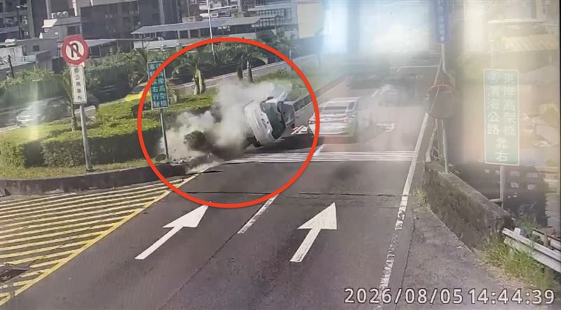 白色轎車撞擊安全島後翻覆滑行。(圖/翻攝畫面)
