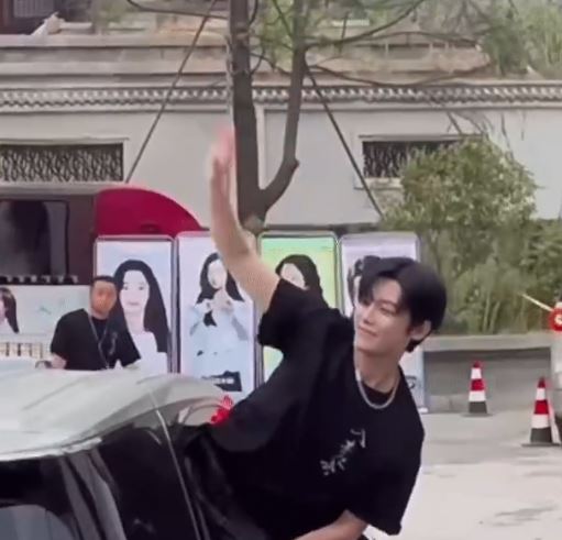 侯明昊為了和粉絲打招呼將頭、手伸出車窗外。(圖/翻攝自微博)