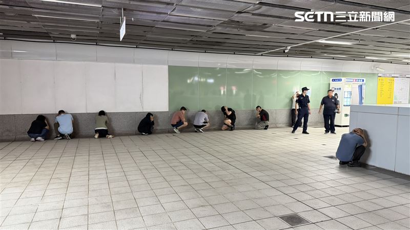 高捷列車均維持正常行駛,不過旅客下車後立即依工作人員引導前往防空疏散避難設施,民眾紛紛靠牆抱頭。(圖/記者簡榮良攝影)