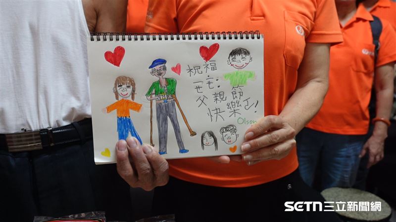 這是一名7歲小男童,得知施阿公從未過過父親節,主動表示要畫卡片送給他。阿公收到人生第一張父親節卡片,非常感動和開心,甚至當場猜出畫中站在身邊的就是大雅志工站站長史丹妮,還得意地說:「這麼像一定是妳啊!」這番話一出逗笑現場的大家。(圖/記者張雅筑攝)